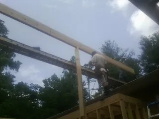 Carpenter setting a ridge beam over a new addition frame — Ice Dam Removal by Roofing Brothers in Estill