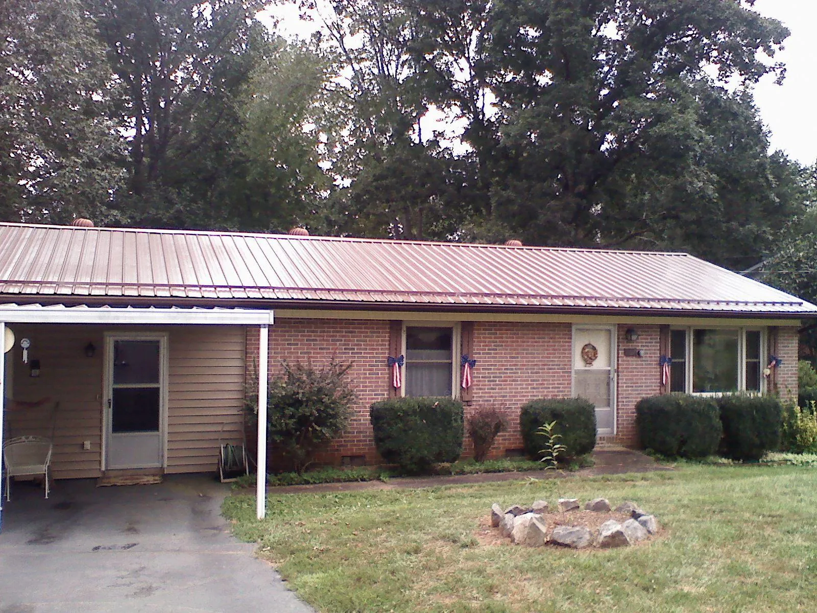 Bronze metal roof and carport on a brick ranch home — Roof Repair work by our crew in Estill